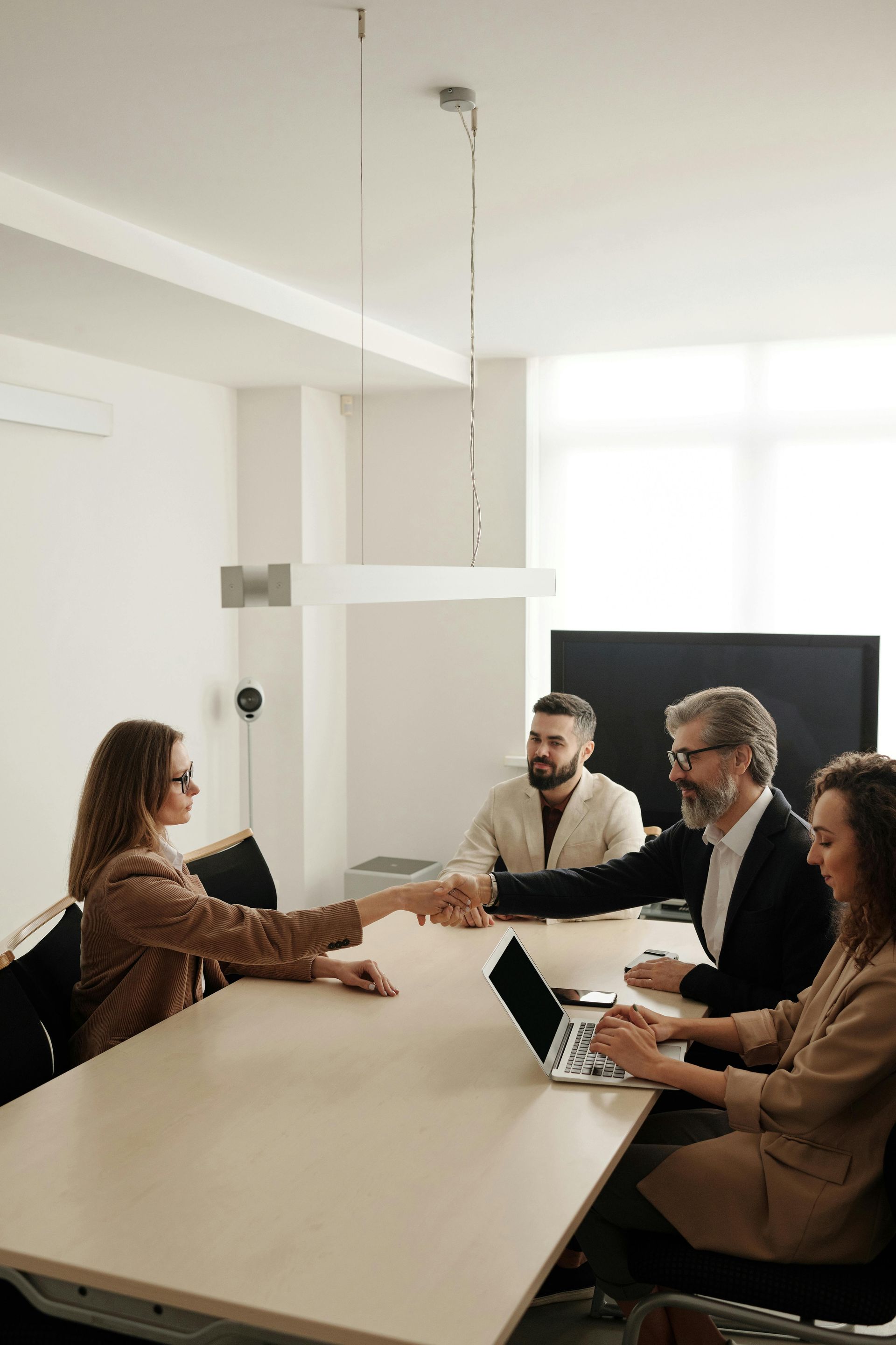 A group of people are shaking hands in a conference room.